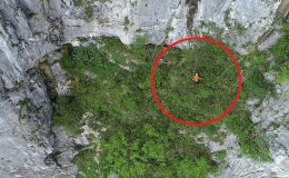 Công nhân đứng trên vách núi cao 1.400 m để dọn rác