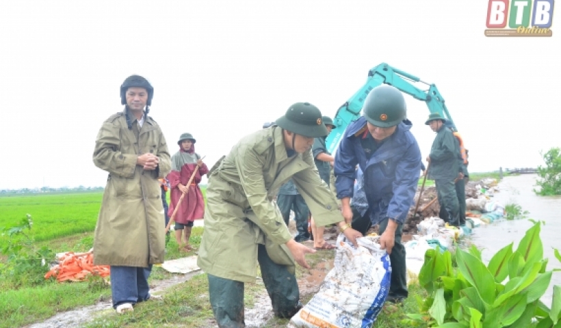 Lực lượng vũ trang huyện Tiền Hải giúp dân đắp đê ngăn nước dâng. Ảnh: Tất Đạt